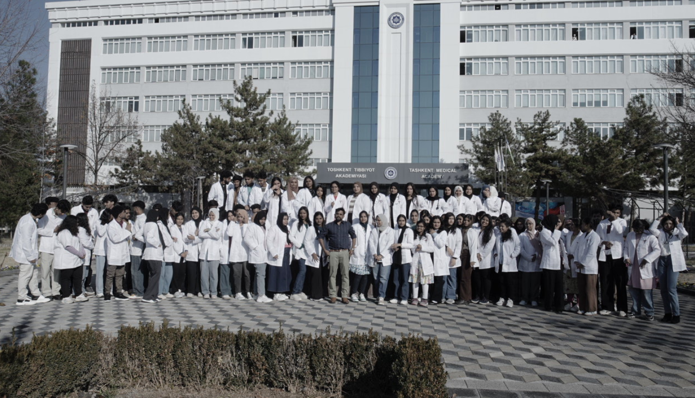 Group of MBBS students in white coats outside their university abroad