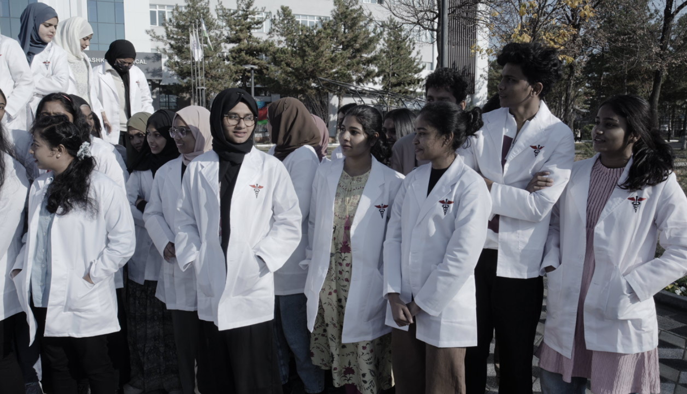 Students in white coats gathered on campus